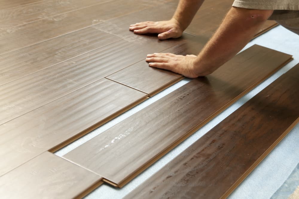 Man Installing New Laminate Wood Flooring Abstract.