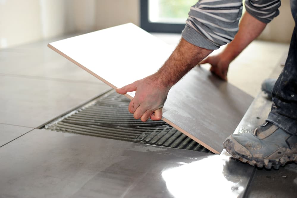 man laying floor tiles