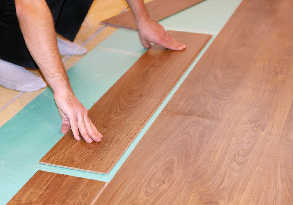 worker installs laminate flooring